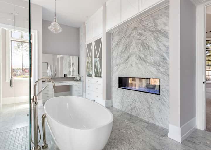 A stand alone tub sets off the marble wall tile in a newly remodeled Winder, GA home.